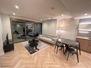 伦敦2 Bedroom Modern Family Flat-Apartment Fulham London的客厅配有桌子和沙发