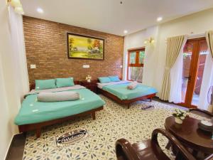 顺化Tâm Family Homestay-Huế的一间卧室配有两张床、一张桌子和一张桌子