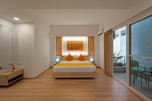 班加罗尔Nest By Rivido Apart Hotel, Bannerghatta road的一间带特大号床的卧室和一个阳台