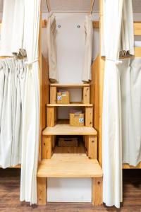 长崎Almas Guest House(アルマス）的衣柜配有木制架子和窗帘