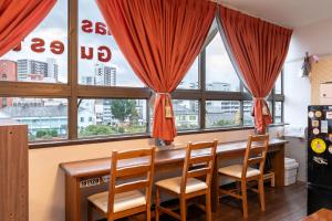 长崎Almas Guest House(アルマス）的一间带桌椅和窗户的用餐室
