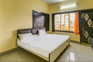 普里Goroomgo Hotel Moon Chakra Tirtha Road Puri - Excellent Stay with Family, Parking Facilities的一间卧室设有一张大床和一个窗户。