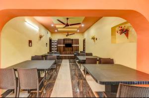 普里Goroomgo Hotel Moon Chakra Tirtha Road Puri - Excellent Stay with Family, Parking Facilities的餐厅配有桌椅和吊扇