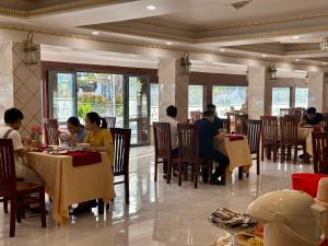 Ấp Mỹ ÐôngCao Lanh Hotel的一群坐在餐厅桌子上的人