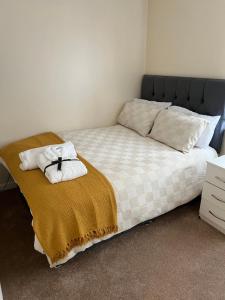 考文垂Soweway Coventry的一间卧室配有一张带毯子和枕头的床。