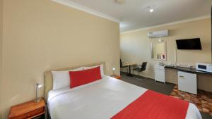 蒂默特Ashton Motel的酒店客房设有一张带红色枕头的大床