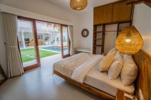 塞隆贝拉纳克Palm Merah Villas - Private pool的一间卧室配有一张床和一个吊灯