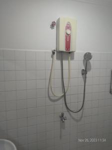 金边Rhythm Bollywood Guesthouse的浴室设有淋浴,墙上配有电话