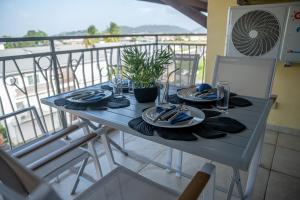 卡宴L'élégance citadine的阳台上的蓝色桌子,上面摆放着盘子和餐巾