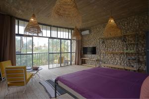 加夫萨dar seddik的一间卧室配有一张紫色的床和一台电视机
