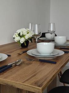 雷布尼克***Santorini Apartament*** - 40m² ✓的木桌,带盘子和酒杯,鲜花