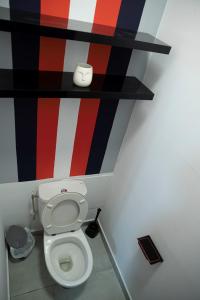 卡宴L'élégance citadine的浴室设有卫生间,墙壁为红色的白色和黑色。
