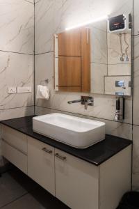 大诺伊达Sandane Homes By The Lodgers Near India Expo Centre & Mart Greater Noida的浴室设有白色水槽和镜子