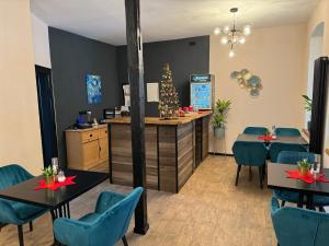 塔勒Aneton Garni Hotel的餐厅设有蓝色椅子和拥有圣诞装饰的柜台。