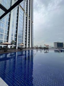 巴淡岛中心Wawa Guesthouse Pollux Habibie Batam Tower A 18的一座高楼前的大型游泳池