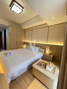 巴淡岛中心Wawa Guesthouse Pollux Habibie Batam Tower A 18的卧室配有一张白色的大床和一张桌子