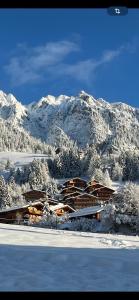 阿尔卑巴赫Tirol Juwel的一座有雪覆盖的山丘的建筑