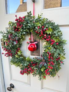 奇平卡姆登Merriman Cottage的红饰门上的圣诞花环