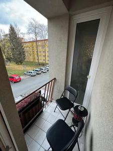 乌赫尔堡Morava apartmán Uherské Hradiště Šafaříkova 855的阳台配有两把椅子,享有街道的景色