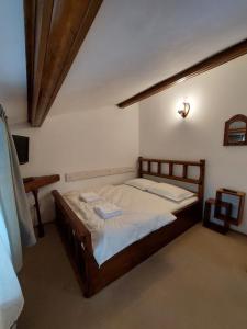 阿祖加Casa Zaharia Azuga的一间卧室配有一张带白色床单的木床