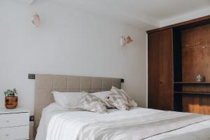 维纳德马Departamento dúplex frente al mar en Reñaca的卧室内的一张带白色床单和枕头的床