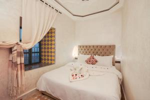 马拉喀什里亚德阿扎利亚酒店的卧室配有白色的床和窗户。