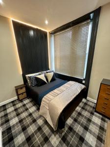 ElswickBotanica @ The.Villas.Newcastle的一间卧室设有一张床和一个大窗户