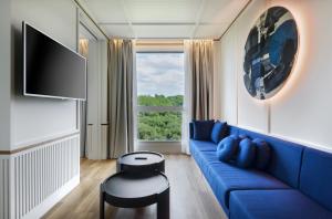 圣塞瓦斯蒂安Hotel Tres Reyes San Sebastián的客厅设有蓝色的沙发和窗户。