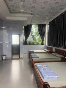 Xã Bình HòaNhà Nghỉ A&Em的一间卧室设有四张床和大窗户