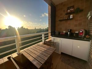 巴雷里尼亚斯Gran Lençóis Flat Barreirinhas Apt 509的一个带桌子的阳台和一个美景厨房