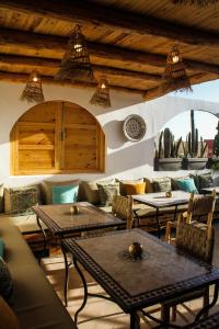 塔姆拉赫特乌兹达尔MAKTUB SURF HOUSE的客厅配有桌子、沙发和仙人掌
