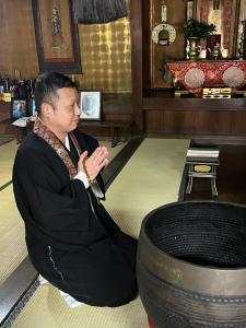 新宫市長徳寺宿坊　Temple Hotel的坐在轮胎旁边的地板上的人