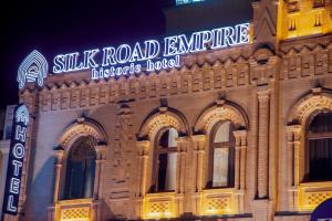 撒马尔罕HOTEL SILK ROAD EMPIRE SAMARKAND的建筑的侧面有标志