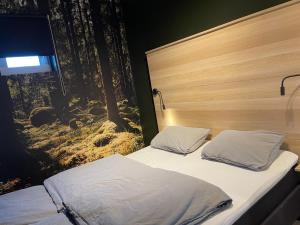 卑尔根Apartment Lilletveitvegen的一间卧室设有两张床,墙上配有电视。