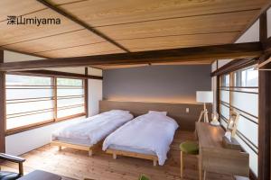 Zentsuji深山邸miyama-tei的配有木天花板的客房设有两张床。