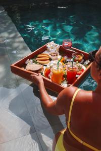 高兰Alanta Pool Villa的把食物托盘放在泳池里的女人