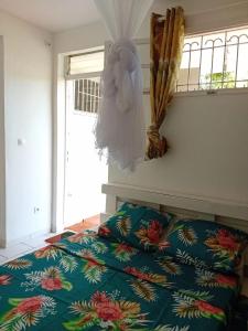 Le Morne RougeKay Anaisa的卧室配有一张床,墙上设有雕像