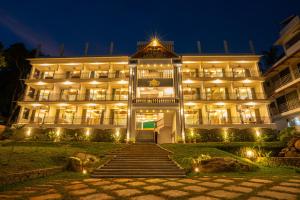 特里凡得琅Aadisaktthi Leisure Resort, Kovalam的一座大型建筑,在晚上前有楼梯