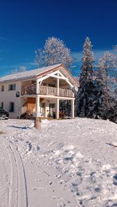 La Chaux-du-DombiefGîte des Roches的雪地里的房子,雪地里留下脚印