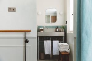 巴黎HOY Paris - Yoga Hotel的浴室配有盥洗盆、镜子和毛巾