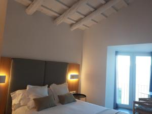 代尔特布雷MAS CATXINA Hotel Boutique 4 estrellas的一间卧室配有一张带白色床单的床和一扇窗户。