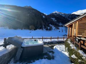 格雷索圣尚De Goldene Traum的小屋旁的雪地里设有热水浴池