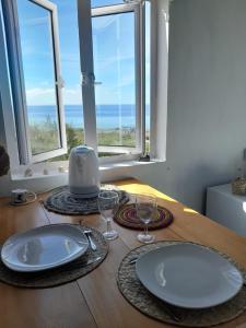 Rodrigues IslandBlue View Terrace的桌子上带窗户的盘子和玻璃杯