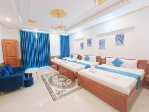 芹苴Phuong Thuy Hotel的一间卧室配有两张床和一张蓝色椅子