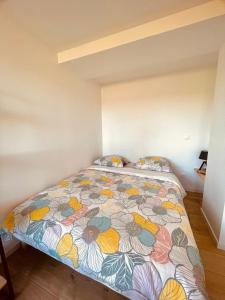 欧什T1 bis rénové au centre d’Auch的一间卧室配有一张带花卉床罩的床