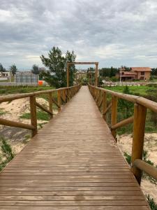 SombrioEdícula aconchegante 100m do Mar的木桥在海滩上的木道