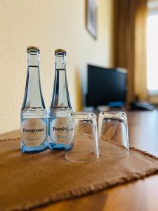 吕嫩TM Hotel Westfalen的桌子上放着两瓶和两杯