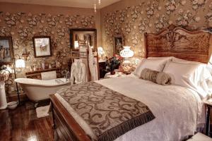 贝尔丰特维多利亚女王住宿加早餐旅馆的一间卧室配有一张床、一个浴缸和一个浴缸