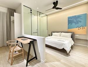 乔治市Designer Guesthouse Pulau Tikus & Gurney Drive, Georgetown, Penang的一间卧室配有一张床和一张桌子及椅子