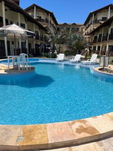 贝贝里比Apto 2 quartos - Condomínio Frente Mar的酒店设有一个大型游泳池,配有椅子